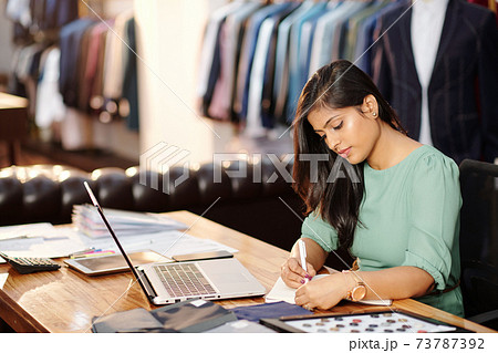 Atelier owner writing in planner 73787392