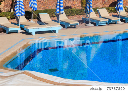 Chaise longues near a swimming pool. Concept of spa, rest, relaxation, holidays, resort 73787890