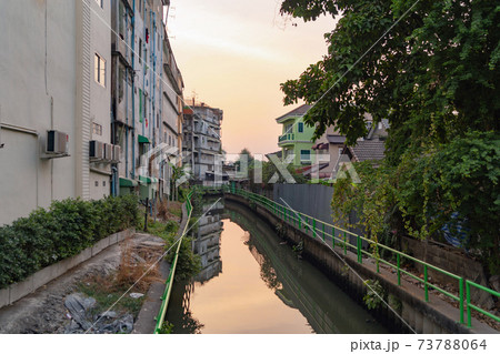 Residential local houses with Phasi Charoen canal, nature trees, Wutthakat district, Bangkok City, Thailand in urban city in Asia. Residential houses, buildings at sunset. 73788064