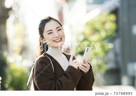 若い女性　スマホ　検索　カメラ目線 73788995