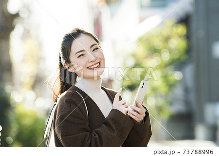 若い女性　スマホ　検索　カメラ目線 73788996