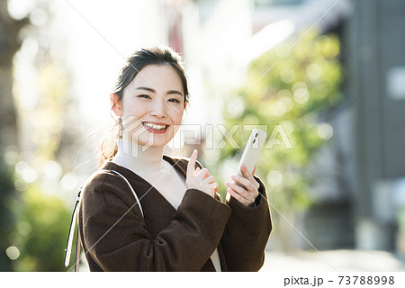 若い女性 スマホ 検索 カメラ目線の写真素材