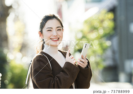 若い女性 スマホ 検索 カメラ目線の写真素材