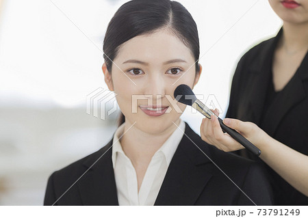 写真スタジオでメイクをしてもらうリクルートスーツの女性 就活 73791249