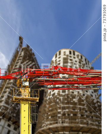 Construction concrete pump (pump truck) with multi-storey building under construction with scaffolding (new residential complex) on the background, Moscow, Russia 73793069