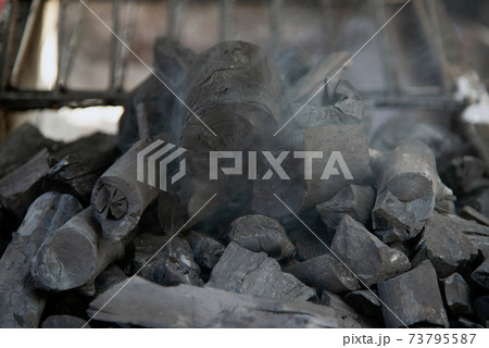 Close up of brightly burning wooden logs with yellow hot flames of fire. 73795587