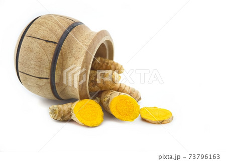 Turmeric roots and a small wooden pot Turmeric roots and a small wooden pot 73796163