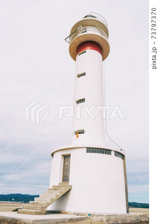 lighthouse on the lonely beach of delta del ebro, tarragona, spain. lighthouse on the lonely beach of delta del ebro, tarragona, spain. 73797370