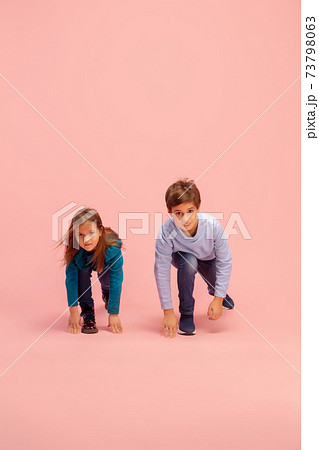 Happy children isolated on coral pink studio background. Look happy, cheerful, sincere. Copyspace. Childhood, education, emotions concept Happy children isolated on coral pink studio background. Look happy, cheerful, sincere. Copyspace. Childhood, education, emotions concept 73798063