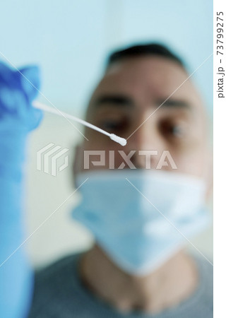 about to take a nasopharyngeal sample to a patient about to take a nasopharyngeal sample to a patient 73799275