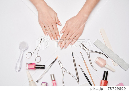 top view of manicure tools set for nail care over light background - brush, scissors, nail polish, file and tweezers 73799899