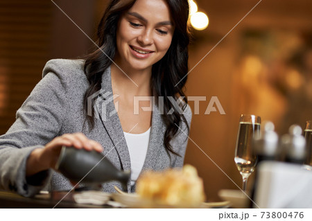 Smiley young lady adding soy sauce from tiny bottle Smiley young lady adding soy sauce from tiny bottle 73800476