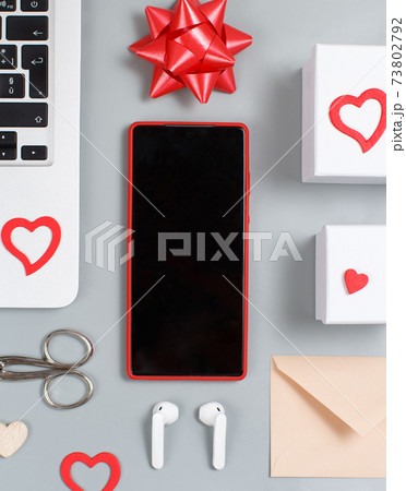 Mobile phone, Hearts, bow, laptop, earphones, scissors, gift boxes top view. Valentines Day concept 73802792