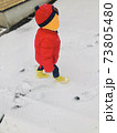雪を歩く子供 73805480