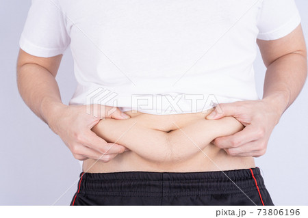 Fat man holding excessive fat belly, overweight fatty belly isolated grey background. Diet lifestyle, weight loss, stomach muscle, healthy concept. 73806196