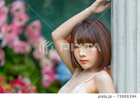 Portrait of young pretty sexy Asian woman wearing bikini in garden. 73806394