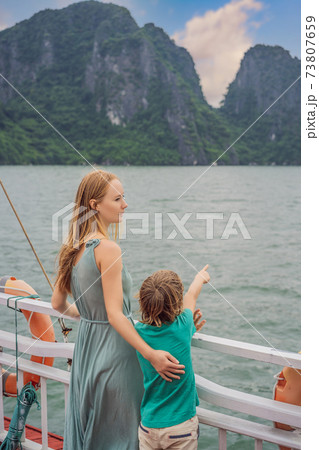 Mom and son travelers is traveling by boat in Halong Bay. Vietnam. Travel to Asia, happiness emotion, summer holiday concept. Traveling with children concept. After COVID 19. Picturesque sea landscape 73807659