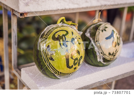 Water melons with festive engraving on Tet Eve. Tet is Lunar New Year and celebrated during four days in Vietnam Water melons with festive engraving on Tet Eve. Tet is Lunar New Year and celebrated during four days in Vietnam 73807701