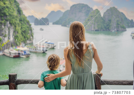 Mom and son travelers in Halong Bay. Vietnam. Travel to Asia, happiness emotion, summer holiday concept. Picturesque sea landscape. Ha Long Bay, Vietnam. After coronavirus COVID 19 Mom and son travelers in Halong Bay. Vietnam. Travel to Asia, happiness emotion, summer holiday concept. Picturesque sea landscape. Ha Long Bay, Vietnam. After coronavirus COVID 19 73807703