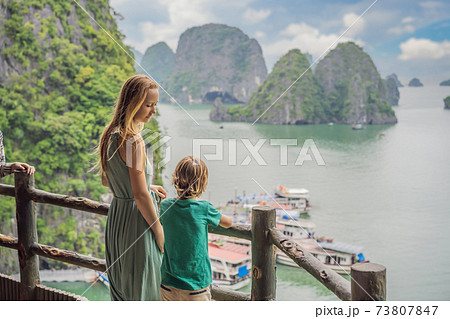 Mom and son travelers in Halong Bay. Vietnam. Travel to Asia, happiness emotion, summer holiday concept. Picturesque sea landscape. Ha Long Bay, Vietnam. After coronavirus COVID 19 Mom and son travelers in Halong Bay. Vietnam. Travel to Asia, happiness emotion, summer holiday concept. Picturesque sea landscape. Ha Long Bay, Vietnam. After coronavirus COVID 19 73807847