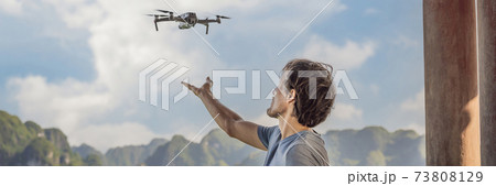 BANNER, LONG FORMAT Man controls a drone in Halong Bay. Vietnam. Travel to Asia, happiness emotion, summer holiday concept. Picturesque sea landscape. Ha Long Bay, Vietnam 73808129