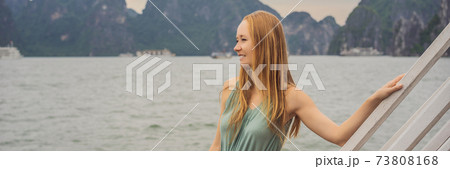 BANNER, LONG FORMAT Attractive woman in a dress is traveling by boat in Halong Bay. Vietnam. Travel to Asia, happiness emotion, summer holiday concept. Picturesque sea landscape. Ha Long Bay, Vietnam 73808168