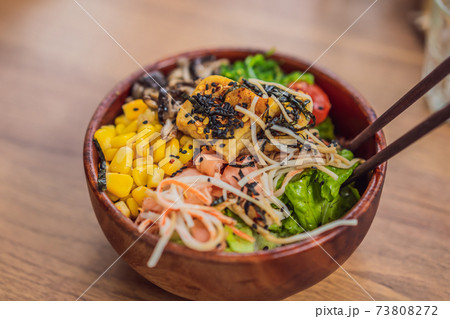 Raw Organic Poke Bowl with Rice and Veggies close-up on the table. Top view from above horizontal 73808272