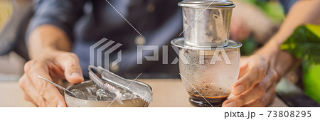 Caucasian man and traditional drip brewed Vietnamese coffee from a phin filter BANNER, LONG FORMAT 73808295
