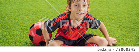 BANNER, LONG FORMAT Little cute kid boy in red football uniform playing soccer, football on field, outdoors. Active child making sports with kids or father, Smiling happy boy having fun in summer 73808345