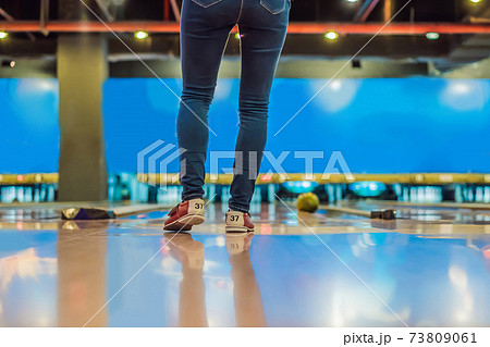 Woman playing bowling with medical masks during COVID-19 coronavirus in bowling club 73809061