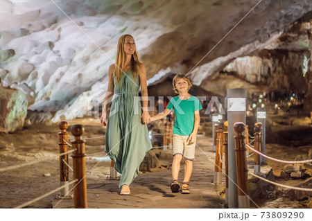 Mom and son tourists in Hang Sung Sot Grotto Cave of Surprises, Halong Bay, Vietnam. Traveling with children concept. Tourism after coronavirus 73809290