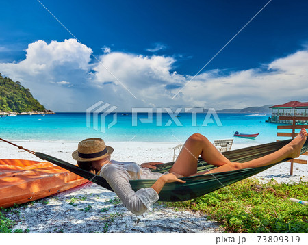 Woman in hammock on beach Woman in hammock on beach 73809319