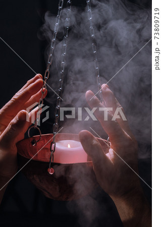 Religious ceremony with a lit candle 73809719