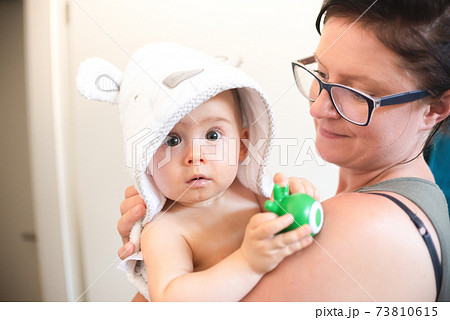 Mother holding baby with bathrobe after eavning bath. 73810615