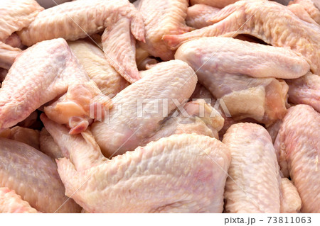 Raw chicken wings close-up. A bunch of chicken wings scattered over the surface. 73811063