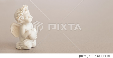 Banner, figurine of an angel Cupid with a bow on a pink background. Valentine's Day. Banner, figurine of an angel Cupid with a bow on a pink background. Valentine's Day. 73811416