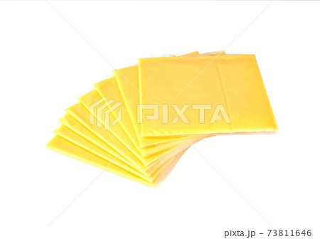 Slices of processed cheese on a white background. Square slices of cheese for a burger close-up. Slices of processed cheese on a white background. Square slices of cheese for a burger close-up. 73811646