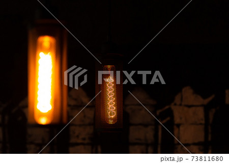 Incandescent lamp. Glowing retro lamp in metal shade. Lamp in the interior. Incandescent lamp. Glowing retro lamp in metal shade. Lamp in the interior. 73811680