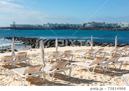 Rows of empty chaise-lounges on the beach in the city of Costa Teguise. Rows of empty chaise-lounges on the beach in the city of Costa Teguise. 73814966