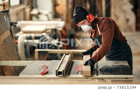 Woodworker cutting wood in workshop Woodworker cutting wood in workshop 73815294