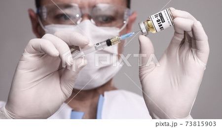 COVID-19. Doctor scientist collects the vaccine to vaccinate the patient. male researcher testing vaccine at the lab.  73815903