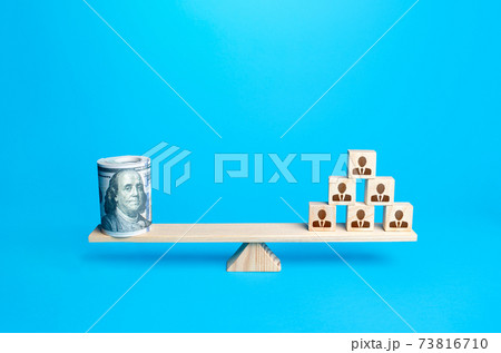 People blocks pyramid and rolled up bundle of dollars on scales. Financing the company and remuneration of staff. Organization accounting. Investments in human capital. Tax collection. Salary fund. People blocks pyramid and rolled up bundle of dollars on scales. Financing the company and remuneration of staff. Organization accounting. Investments in human capital. Tax collection. Salary fund. 73816710