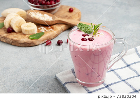 Homemade yogurt smoothie with banana, cranberry and oatmeal, copy space 73820204