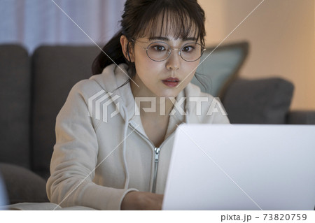 ノートパソコンで作業をする若い女性 73820759
