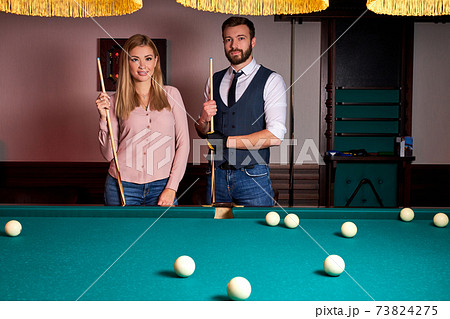 beautiful couple spend pleasant pastime playing billiards together, family rest, entertainment, holiday 73824275