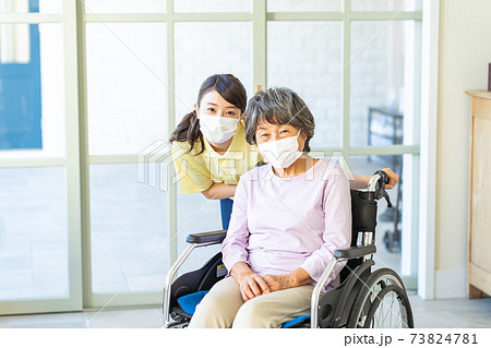 マスクをした若いヘルパーとシニア女性 マスクをした若いヘルパーとシニア女性 73824781