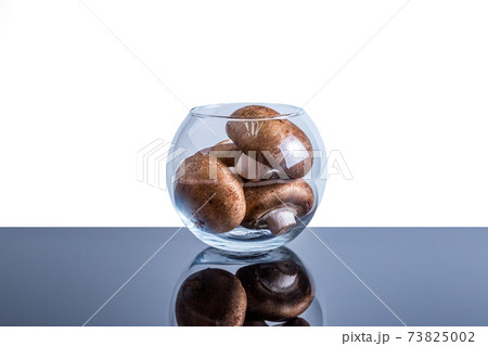 Transparent vase filled to the top with edible mushrooms with copy space 73825002