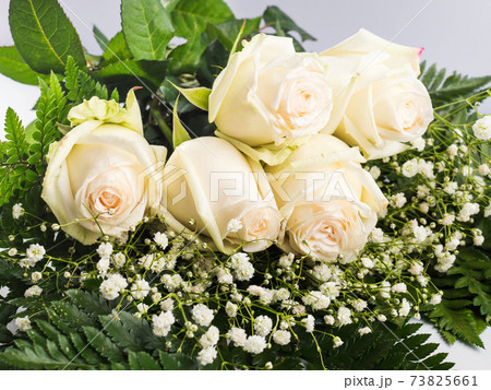 White roses bouquet as gift on a holiday on gray White roses bouquet as gift on a holiday on gray 73825661