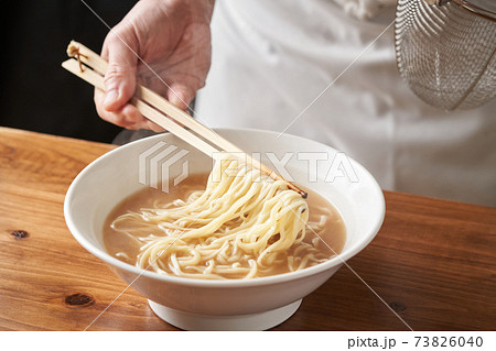 ラーメンを盛り付けるラーメン店主の写真素材