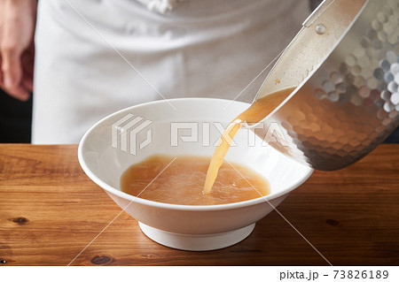 ラーメンのスープを注ぐラーメン店主 73826189